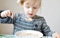 Little Blond Girl Eating Healthy Breakfast Flakes with Milk