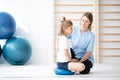 Little blond girl exercising with her professional physician