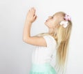 Little blond girl folded her hands in prayer to God. A little an