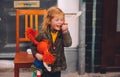 Little blond girl and her orange hair doll on King`s Day festivity, Netherlands