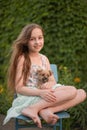 A little blond girl with her pet dog outdooors in park