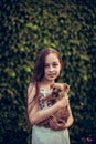 A little blond girl with her pet dog outdooors in park