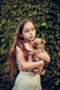 A little blond girl with her pet dog outdooors in park
