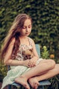 A little blond girl with her pet dog outdooors in park