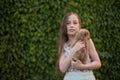 A little blond girl with her pet dog outdooors in park