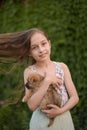 A little blond girl with her pet dog outdooors in park