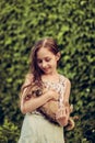 A little blond girl with her pet dog outdooors in park