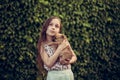 A little blond girl with her pet dog outdooors in park