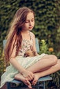 A little blond girl with her pet dog outdooors in park