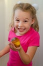 Blonde girl with a grin offers a rotten pear Royalty Free Stock Photo