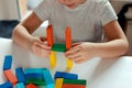 little blond girl playing board games. wooden builing blocks in girl& x27;s hands Royalty Free Stock Photo