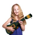 Little blond girl in purple dress plays ukulele Royalty Free Stock Photo