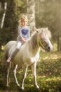 Little blond girl riding little horse pony Royalty Free Stock Photo