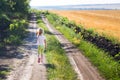 Little blond girl running along dirt rural road
