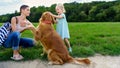 Little blond girl smiling and hugging her cute pet dog golden retriever Royalty Free Stock Photo