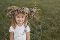 Little blond girl in white with a wreath of flowers on her head Royalty Free Stock Photo