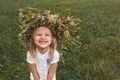 Little blond girl in white with a wreath of flowers on her head Royalty Free Stock Photo