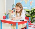 Little blond girl writing classwork in the school classroom Royalty Free Stock Photo