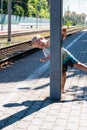 A little blond-haired boy of three years in a T-shirt and shorts on the platform is waiting for the train and playing catch-up - Royalty Free Stock Photo