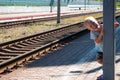 A little blond-haired boy of three years in a T-shirt and shorts on the platform is waiting for the train and playing Royalty Free Stock Photo