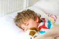 Little blond kid boy in colorful nightwear clothes sleeping Royalty Free Stock Photo