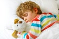 Little blond kid boy in colorful nightwear clothes sleeping Royalty Free Stock Photo