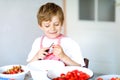 Little blond kid boy helping and making strawberry jam in summer Royalty Free Stock Photo