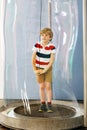 Little blond kid boy playing with huge soap bubbles construction indoors. Happy healthy smiling child having fun with Royalty Free Stock Photo