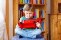 Little blond kid boy playing with wooden toy bus, indoors Royalty Free Stock Photo