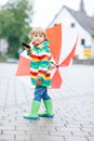 Little blond kid boy walking with big umbrella outdoors Royalty Free Stock Photo