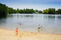 Little blond preschool girl having fun with splashing in a lake on summer day, outdoors. Happy child learning swimming Royalty Free Stock Photo