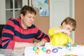 Little blond preschool kid boy and father coloring eggs for Easter holiday Royalty Free Stock Photo