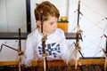 Little blond school kid boy playing with sailing ship model indoors. Excited child with yacht having fun after school at Royalty Free Stock Photo