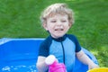 Little blond toddler boy playing with water in summer Royalty Free Stock Photo