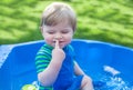 Little blond toddler boy playing with water in summer Royalty Free Stock Photo