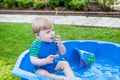 Little blond toddler boy playing with water in summer Royalty Free Stock Photo