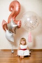 Little blonde baby girl two years old with big pink and white balloons on her birthday party Royalty Free Stock Photo