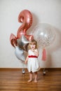 Little blonde baby girl two years old with big pink and white balloons on her birthday party Royalty Free Stock Photo