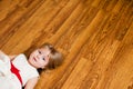 Little blonde baby girl two years old with big pink and white balloons lying on the wooden floor on her birthday party Royalty Free Stock Photo