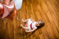 Little blonde baby girl two years old with big pink and white balloons lying on the wooden floor on her birthday party Royalty Free Stock Photo