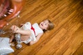 Little blonde baby girl two years old with big pink and white balloons lying on the wooden floor on her birthday party Royalty Free Stock Photo