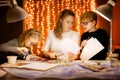 Little blonde boy and girl and their mother writes the letter to Santa