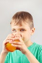 Little blonde boy drinking fresh citrus juice Royalty Free Stock Photo
