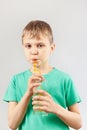 Little blonde boy drinking fresh lemonade through a straw Royalty Free Stock Photo