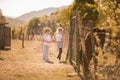 Little blonde boy and girl on the farm with wild horses