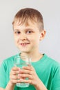 Little blonde boy with glass of fresh mineral water Royalty Free Stock Photo