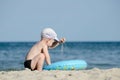 Little blonde boy playing with sand on the seashore Royalty Free Stock Photo