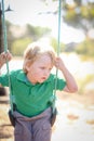 Little blonde boy playing on swing at preschool for kindy portraits Royalty Free Stock Photo