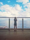 Little blonde Caucasian girl standing on cruise ship deck and looking out on sea ocean. Travelling with kids on cruise liner. View Royalty Free Stock Photo