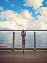 Little blonde Caucasian girl standing on cruise ship deck and looking out on sea ocean. Travelling with kids on cruise liner. View Royalty Free Stock Photo